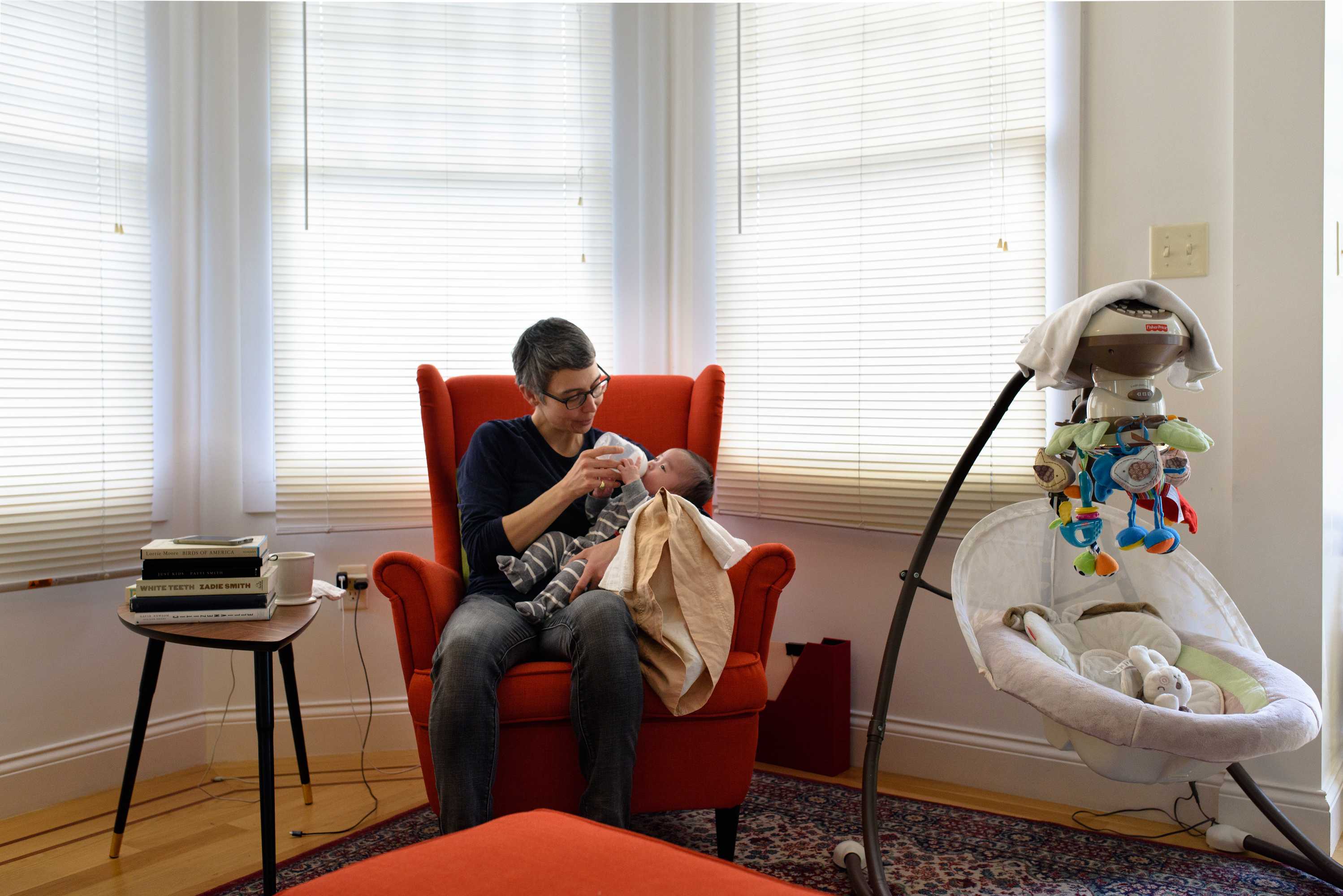 Inger Brinck feeding their four-month old son. They are considering moving out of Oakland as housing costs increase.